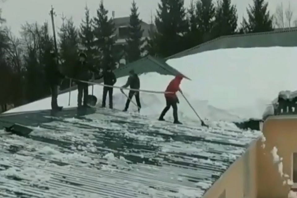 школьники чистят крышу от снега